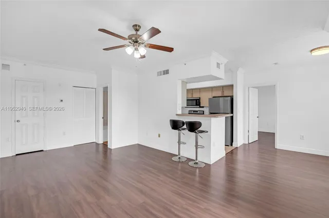 a view of a kitchen with wooden floor and a ceiling fan