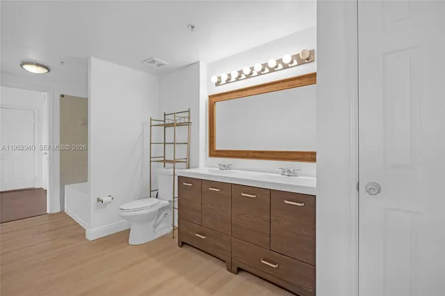 a bathroom with a toilet a sink and mirror