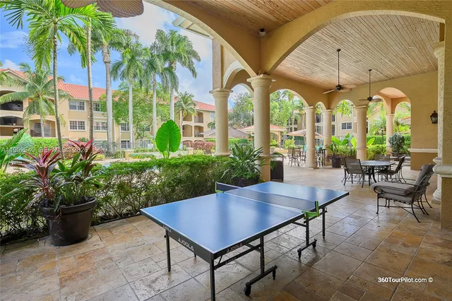 a view of a patio with a table and chairs potted plants