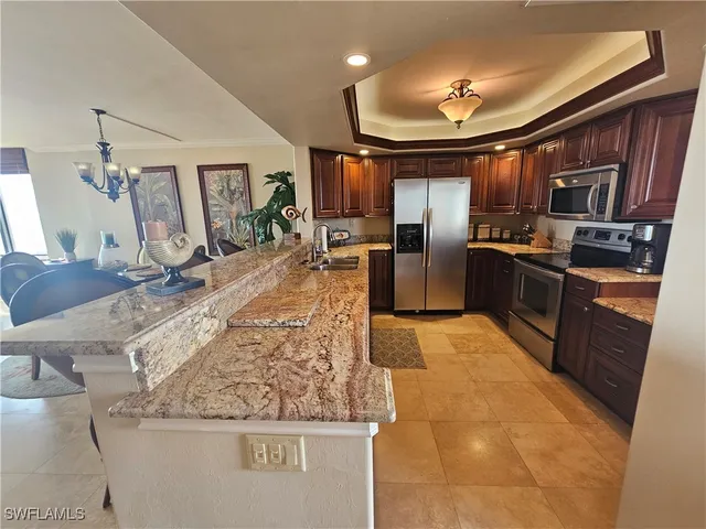 a kitchen with stainless steel appliances granite countertop a sink a stove and a refrigerator