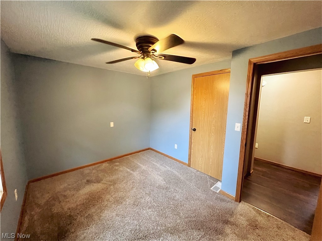 3122 Bedrock Road Northwest Dellroy, OH 44620 - Photo 21 of 23 Unfurnished bedroom with ceiling fan, a closet, carpet, and a textured ceiling
