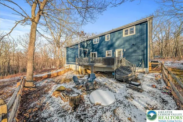 a backyard of a house with fire pit and chairs