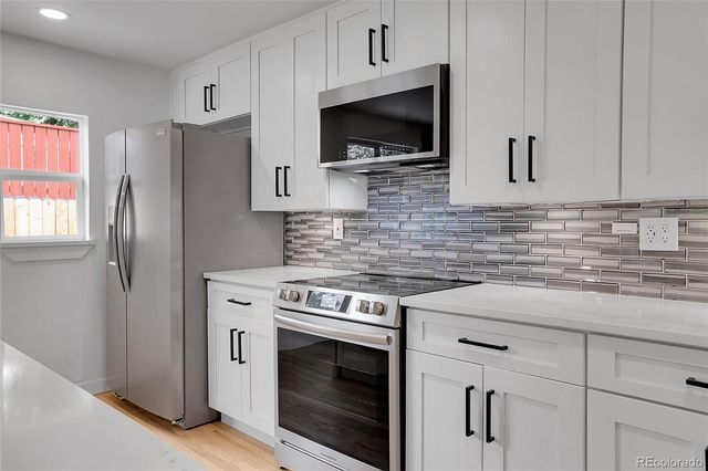 a kitchen with cabinets stainless steel appliances and sink