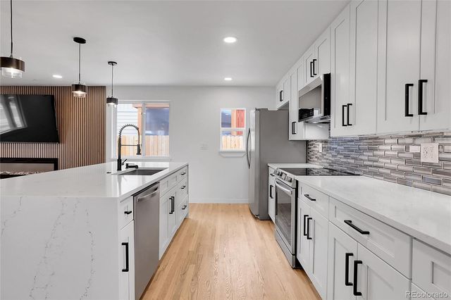 a kitchen with stainless steel appliances granite countertop a sink stove and refrigerator