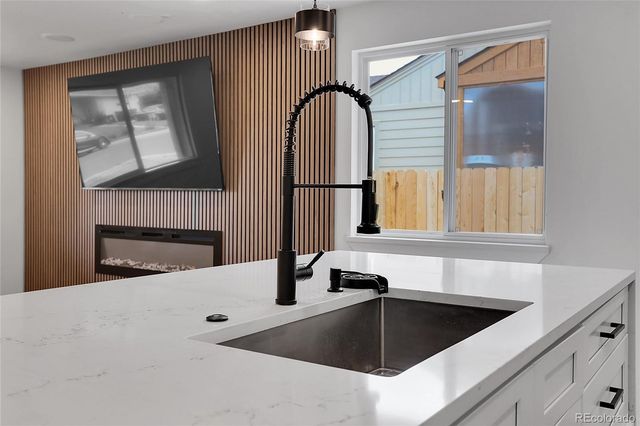 a kitchen with a sink a fireplace and a window