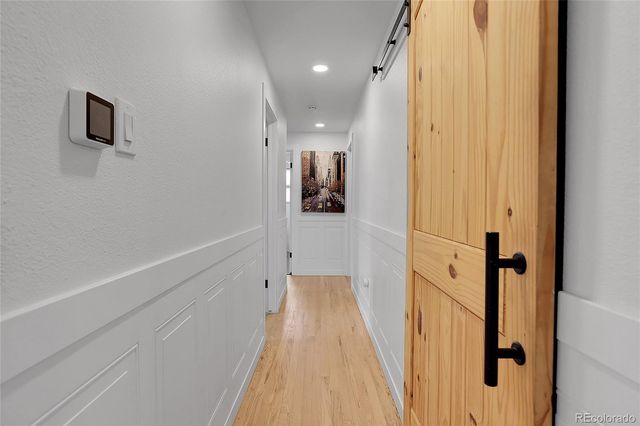 a view of a hallway with wooden floor and staircase
