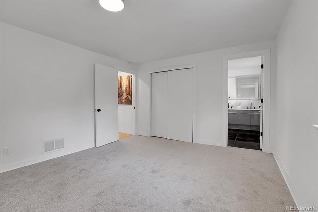 an empty room with windows and a bathroom