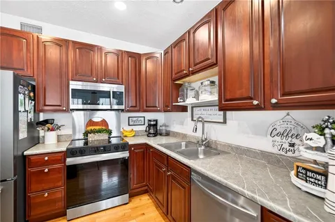 a kitchen with stainless steel appliances granite countertop a sink stove and microwave