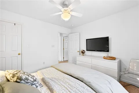 a bedroom with a bed a flat screen tv and a chandelier