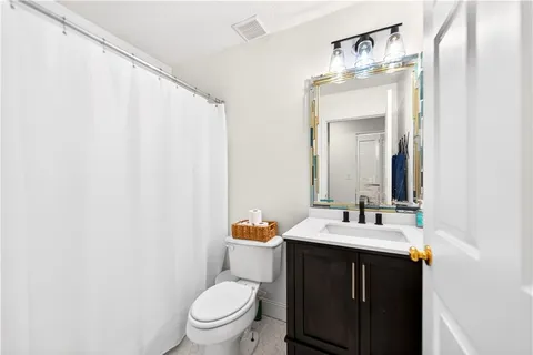a bathroom with a sink vanity mirror and toilet