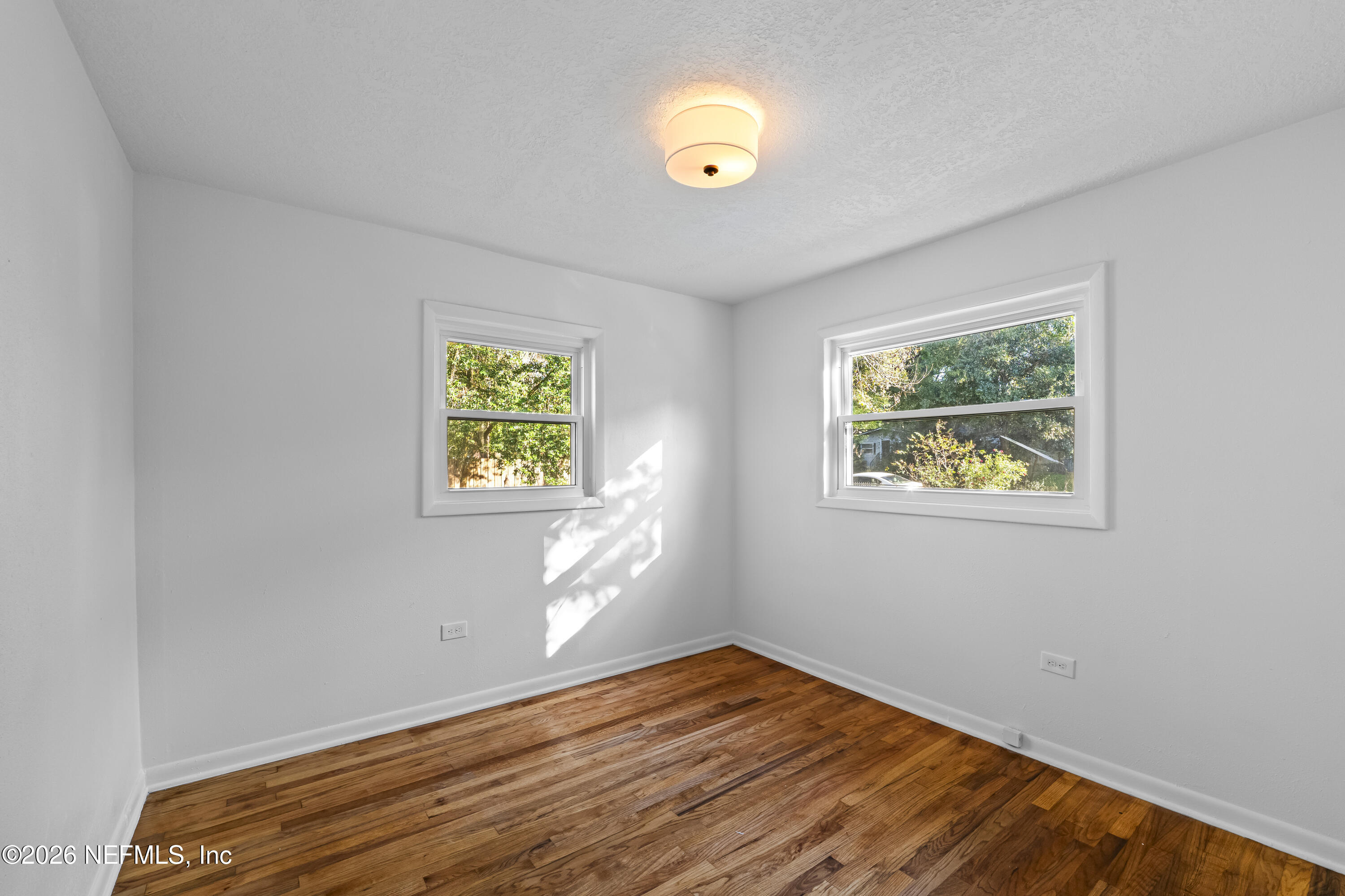 2389 Hilly Road Jacksonville, FL 32208 - Photo 13 of 25 a view of an empty room with window and wooden floor