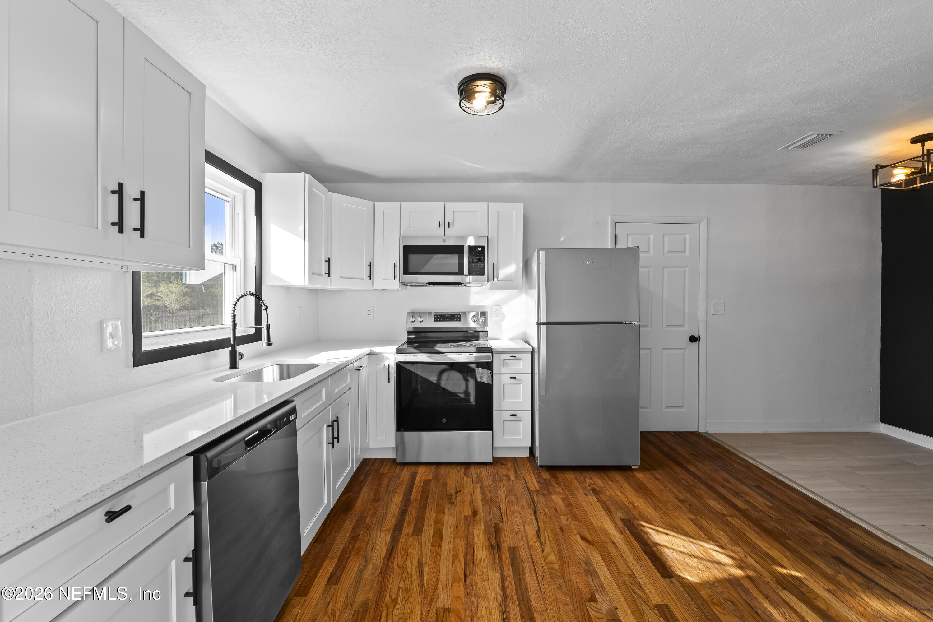 2389 Hilly Road Jacksonville, FL 32208 - Photo 3 of 25 a kitchen with a refrigerator sink and wooden floor