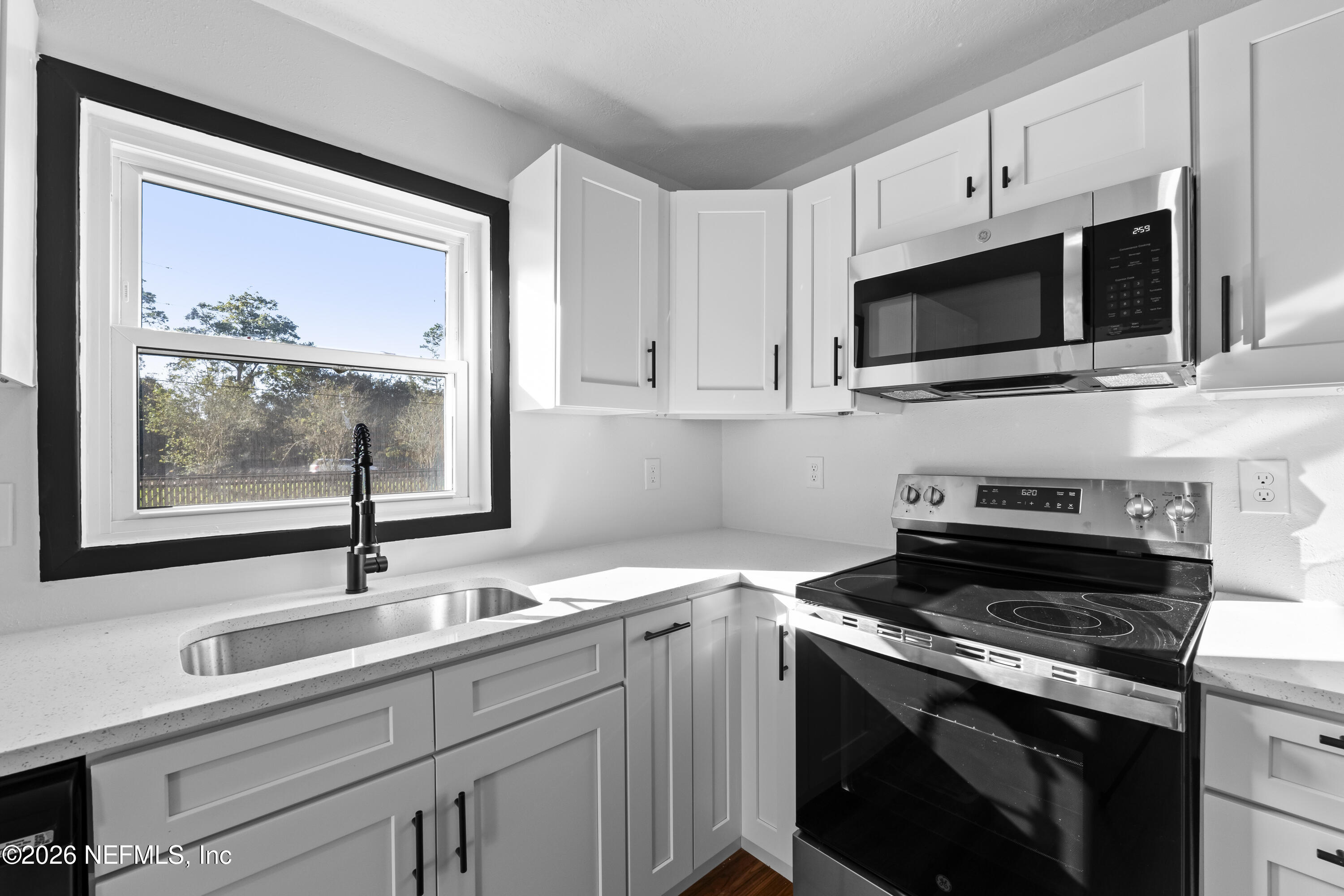 2389 Hilly Road Jacksonville, FL 32208 - Photo 5 of 25 a kitchen with stainless steel appliances a stove microwave and sink