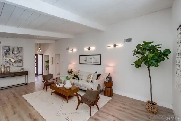 a living room with furniture flowers and a potted plant
