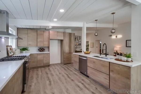 a large kitchen with kitchen island a large counter space a sink stainless steel appliances and cabinets