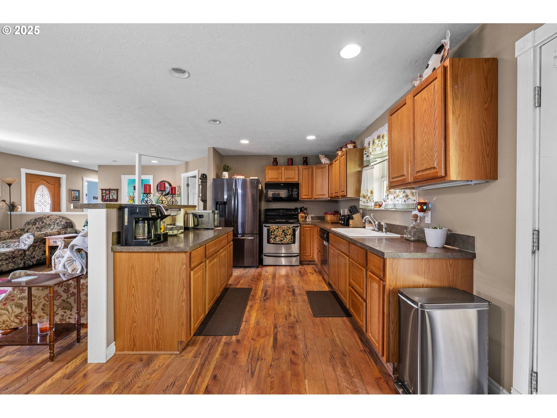 1390 Swedetown Road Clatskanie, OR 97016 - Photo 22 of 42 a kitchen with stainless steel appliances granite countertop a refrigerator a stove top oven a sink dishwasher and white cabinets with wooden floor