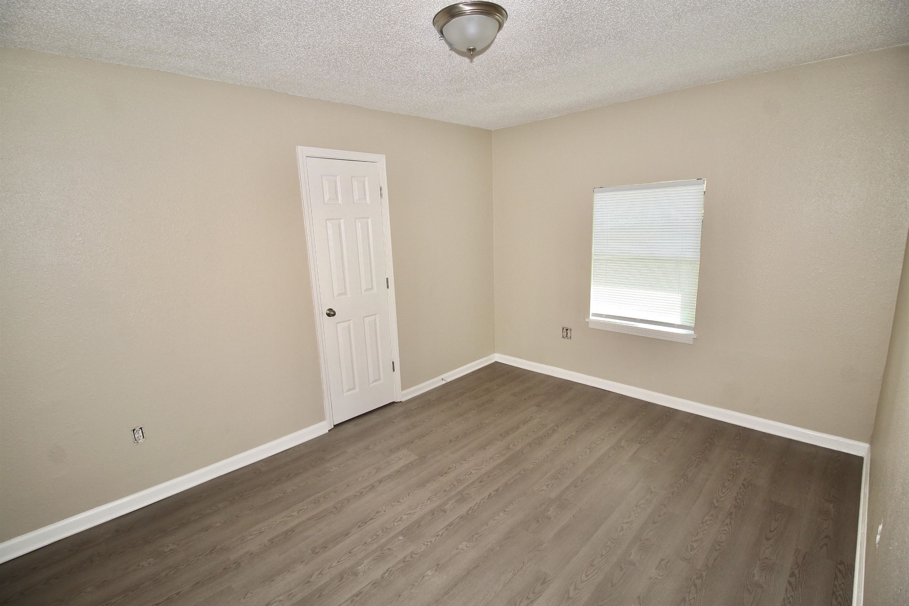 4780 Hillbrook Road Memphis, TN 38109 - Photo 13 of 14 an empty room with wooden floor and windows