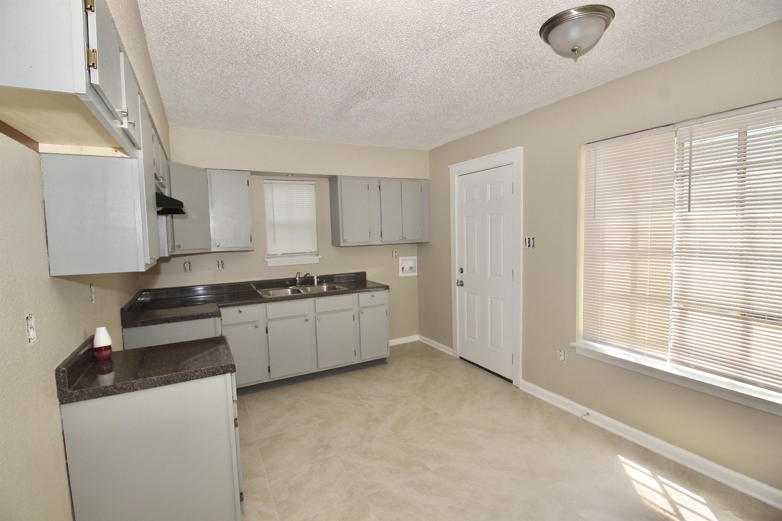 4780 Hillbrook Road Memphis, TN 38109 - Photo 4 of 14 a kitchen with granite countertop a sink cabinets and stainless steel appliances