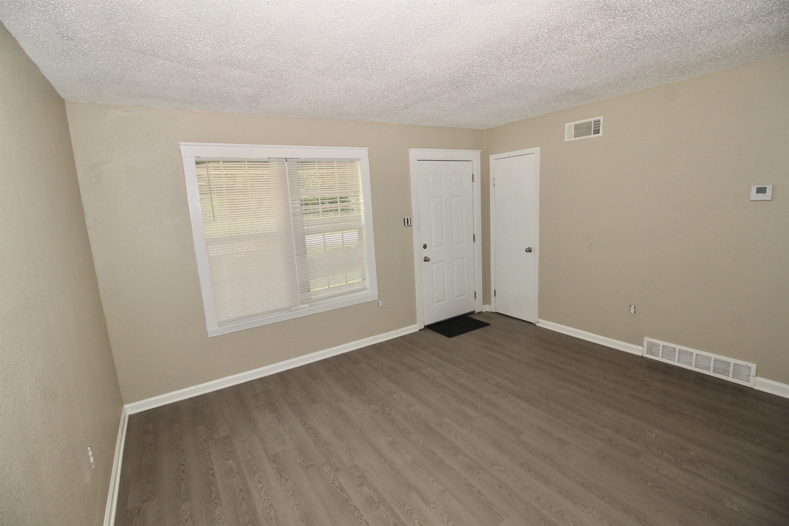 4780 Hillbrook Road Memphis, TN 38109 - Photo 6 of 14 a view of an empty room with wooden floor and a window