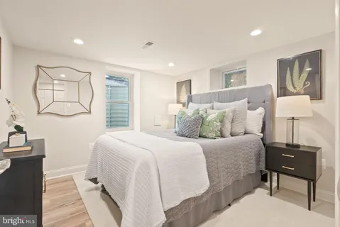 a bathroom with a sink a toilet a mirror and shower