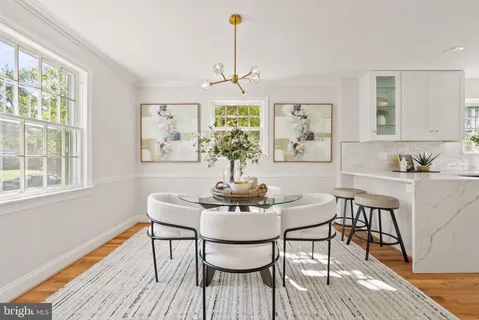 a dining room with furniture a chandelier and wooden floor