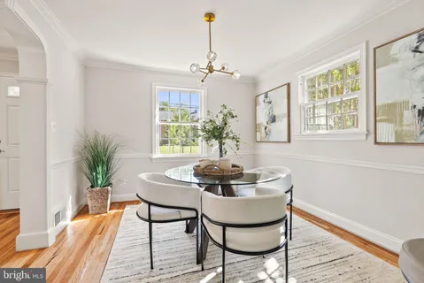 a dining room with furniture a chandelier and wooden floor