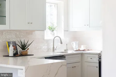 a close view of a sink and dishwasher in a white cabinet