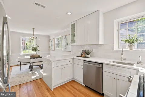 a kitchen with a sink cabinets and wooden floor