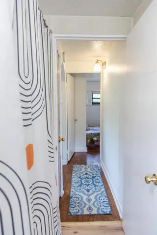 a bedroom with a bed and hardwood floor