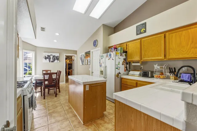 a kitchen with stainless steel appliances granite countertop sink stove and refrigerator