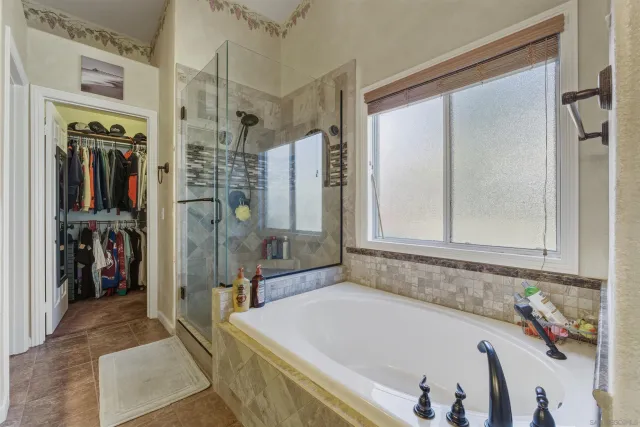 a bathroom with a tub a sink and a shower