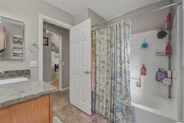 a bathroom with a granite countertop shower curtain and a sink