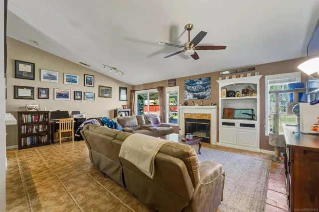 a living room with furniture a fireplace and a flat screen tv