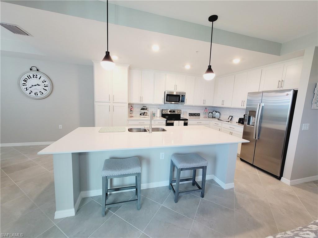 43981 Boardwalk Loop, Unit 2232 Punta Gorda, FL 33982 - Photo 1 of 34 Kitchen featuring sink, appliances with stainless steel finishes, decorative backsplash, and white cabinets