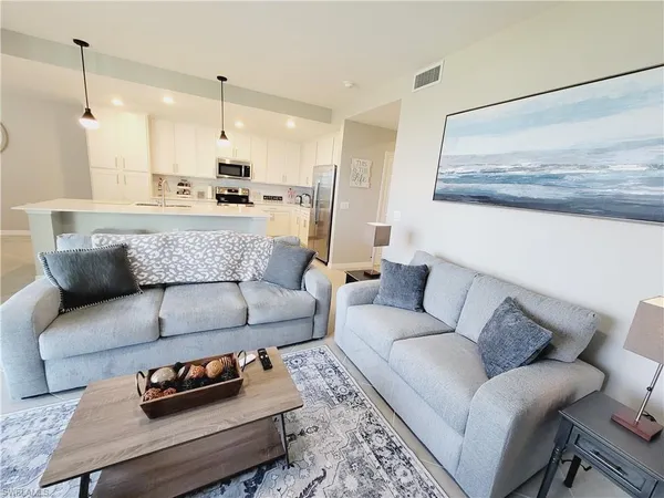 a living room with furniture and kitchen view