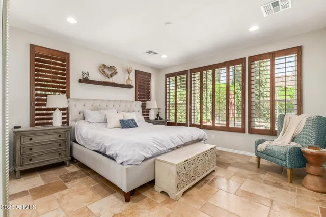 a spacious bedroom with a bed and glass couch