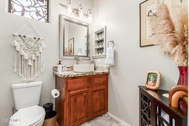 a bathroom with a granite countertop toilet sink and mirror