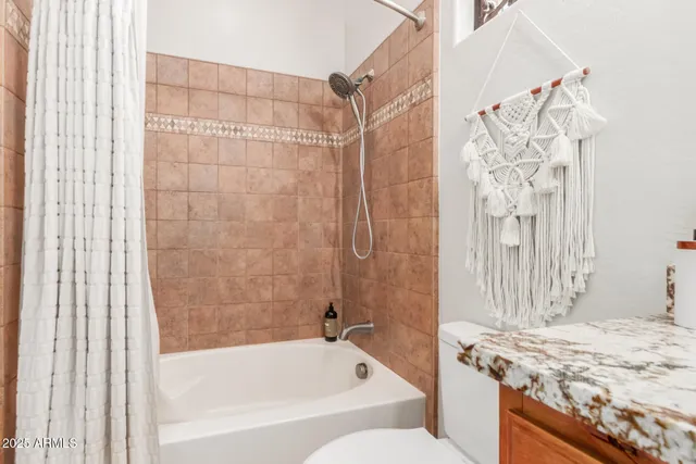 a bathroom with a granite countertop sink a toilet and bathtub