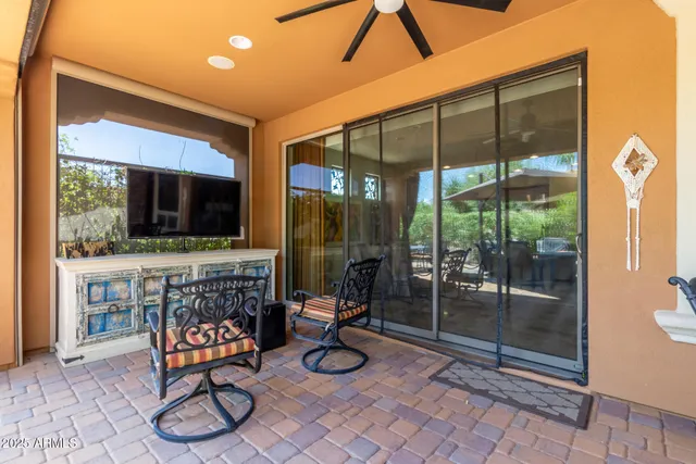 a living room with patio furniture and a flat screen tv