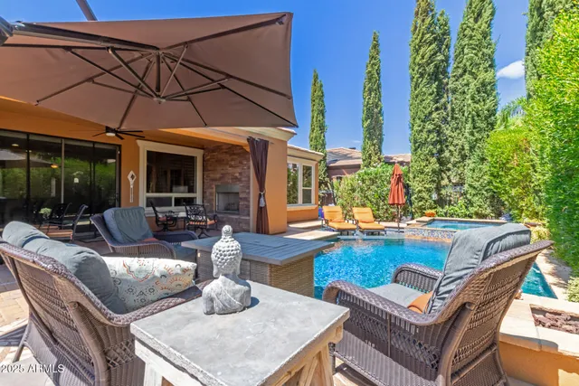 a view of a patio with couches table and chairs under an umbrella