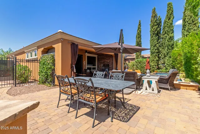 a view of a patio with table and chairs potted plants and floor to ceiling window