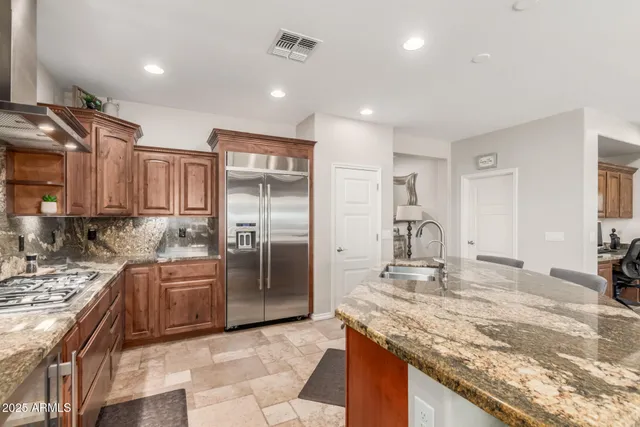 a kitchen with stainless steel appliances granite countertop a sink stove and refrigerator