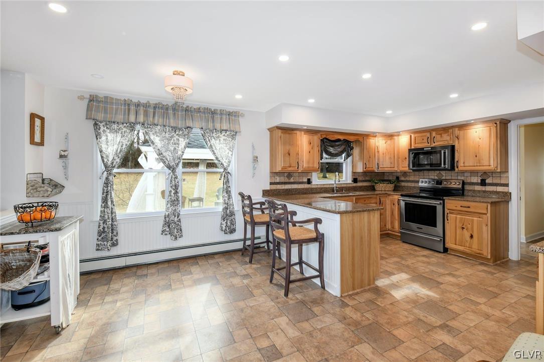 4384 Lehnenberg Road Riegelsville, PA 18077 - Photo 11 of 36 a kitchen with stainless steel appliances granite countertop a stove a sink a microwave a refrigerator and cabinets