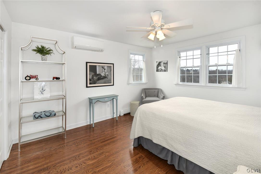 4384 Lehnenberg Road Riegelsville, PA 18077 - Photo 23 of 36 a spacious bedroom with a bed and a chandelier