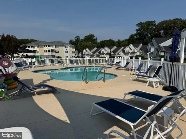 a view of a swimming pool with outdoor seating and a garden