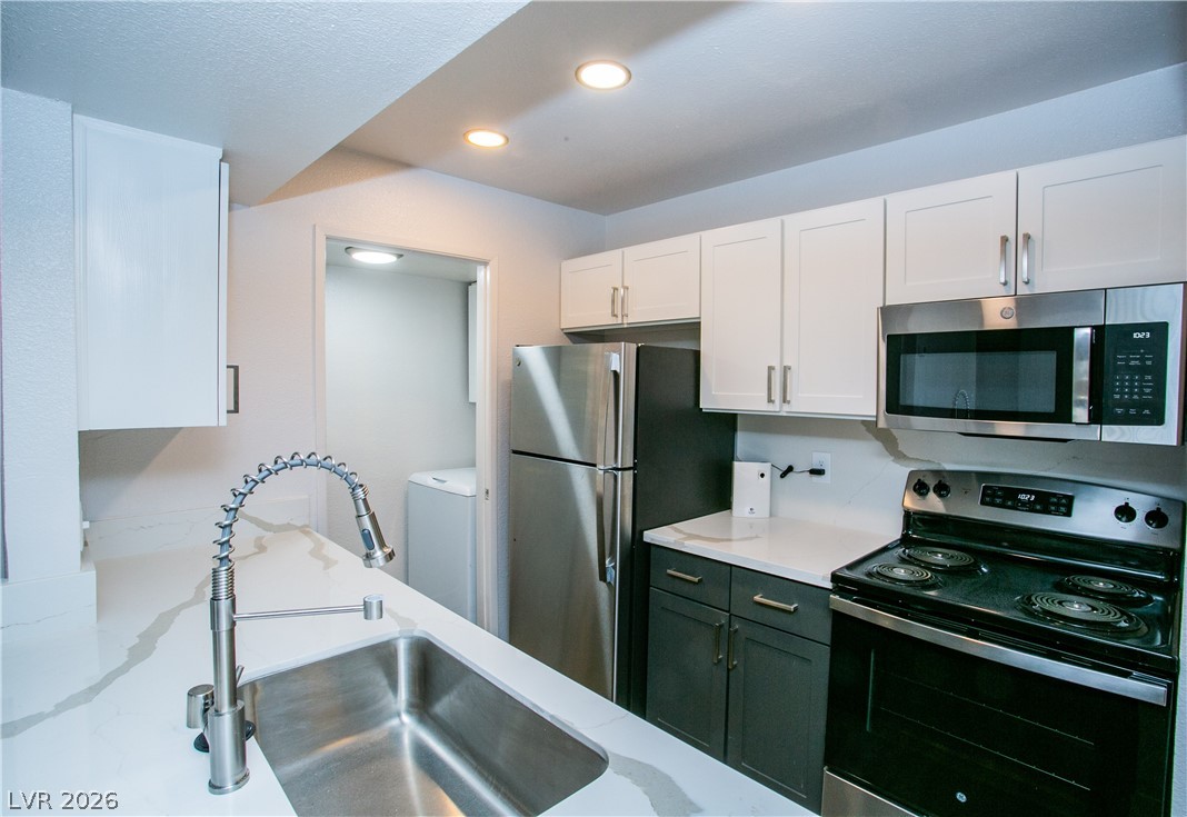 6750 Del Rey Avenue, Unit 108 Las Vegas, NV 89146 - Photo 2 of 11 This modern kitchen features sleek countertops and appliances, offering both style and functionality.