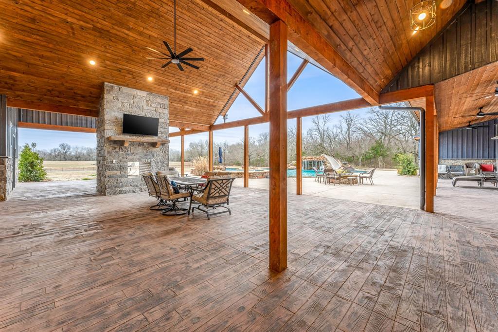 239 32507th Road Paris, TX 75460 - Photo 34 of 40 View of patio with a ceiling fan, an outdoor stone fireplace, outdoor dining area, and an outdoor pool