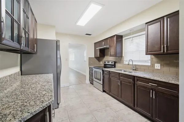 a kitchen with stainless steel appliances granite countertop a sink stove and refrigerator