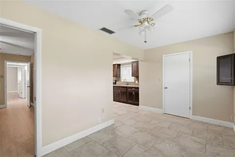 a large white kitchen with a sink a refrigerator and a window