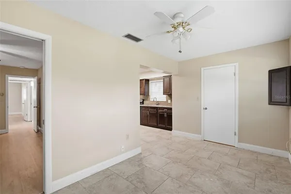 a large white kitchen with a sink a refrigerator and a window